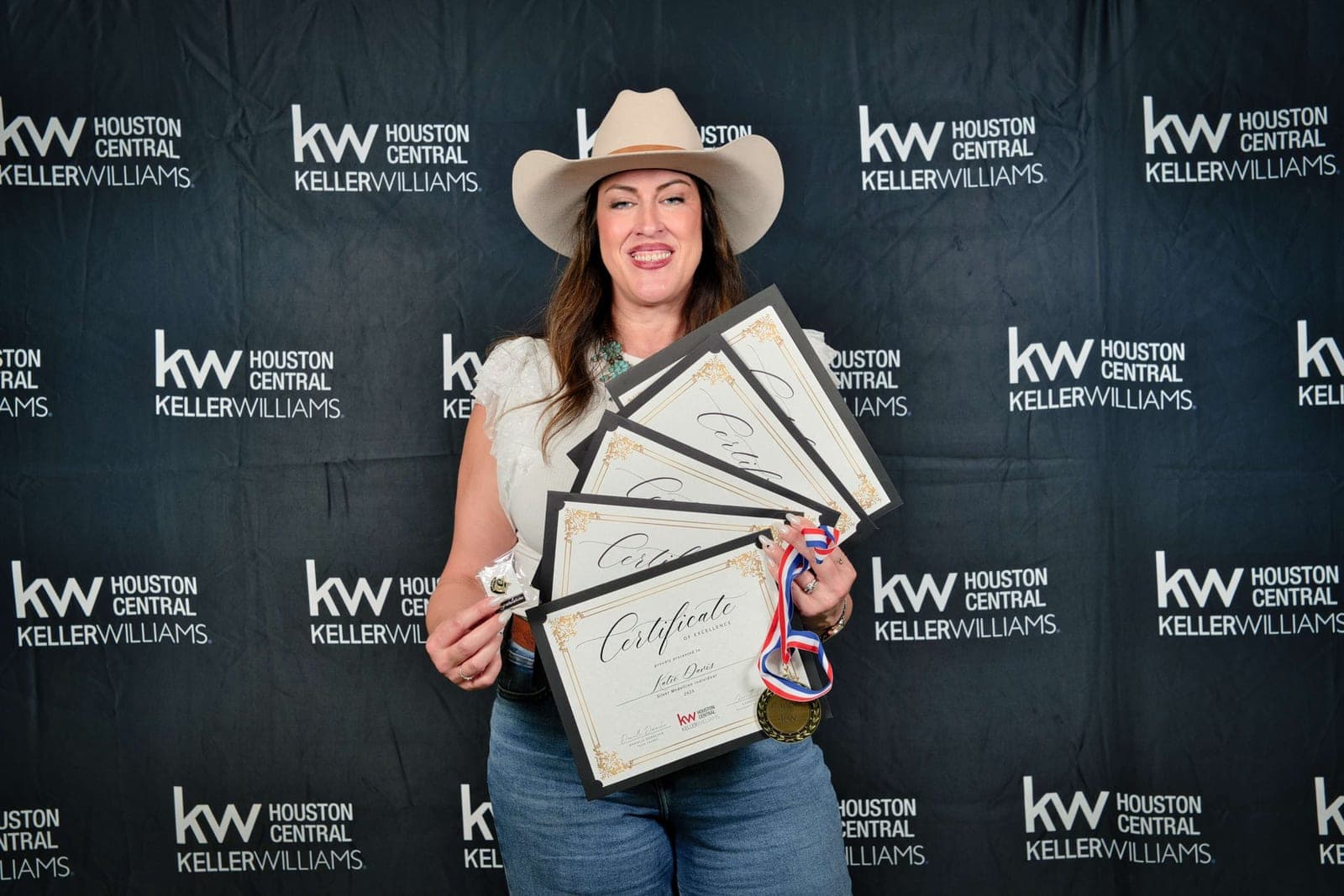Katie Davis holding multiple Certificates of Excellence at Keller Williams Houston Central